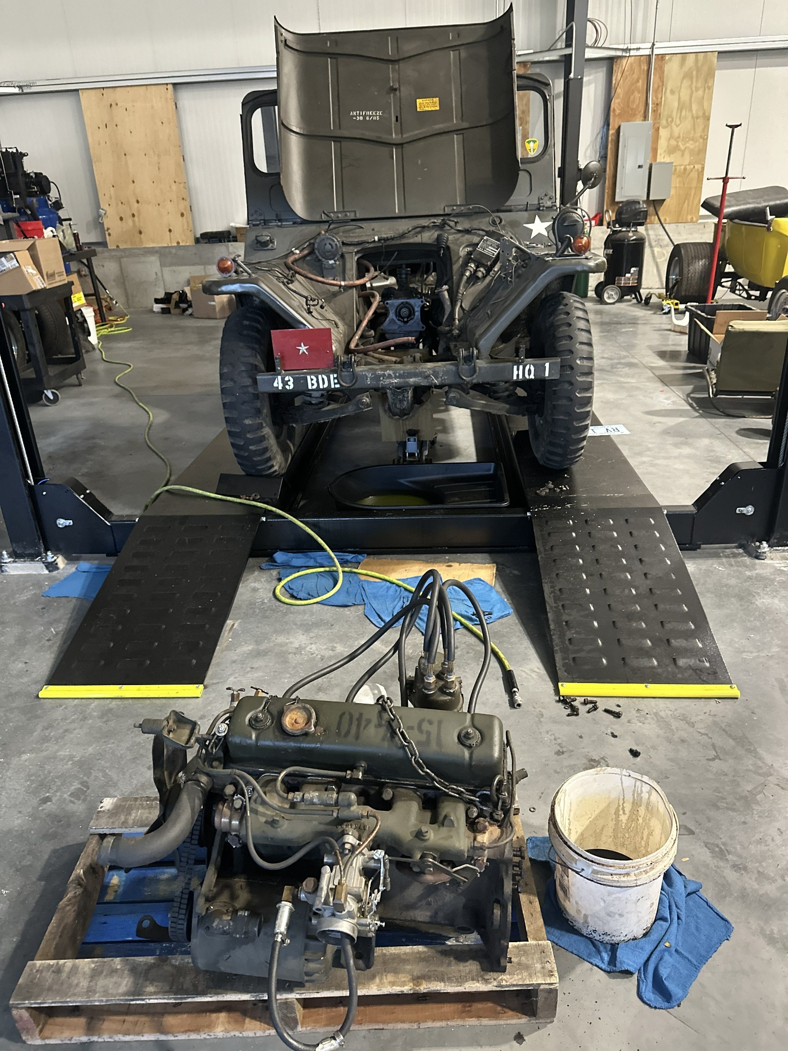Vintage military Jeep on a service platform with its engine in the foreground